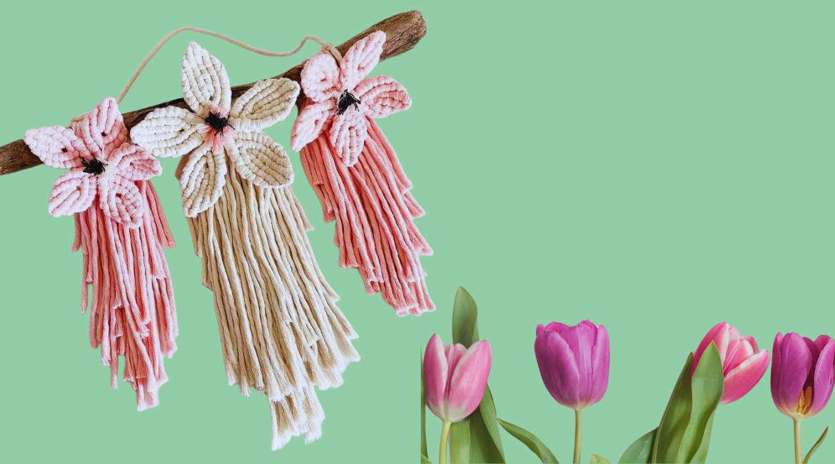 Su uno sfondo verse di stagliano un ramo con delle decorazioni floreali in macramè e dei tulipani freschi.