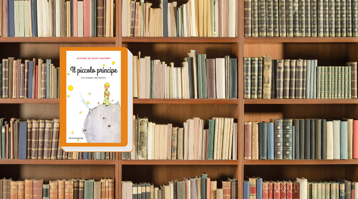 La copertina del libro "Il Piccolo Principe" di Antoine de Saint-Exupéry è bordata di arancione. Sullo sfondo si vede una scaffalatura piena di libri.