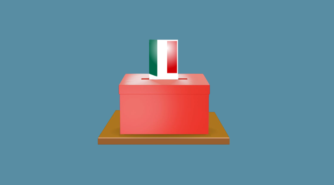 L'immagina rappresenta un'urna rossa con una scheda tricolore che viene inserita all'interno. Lo sfondo è azzurro.